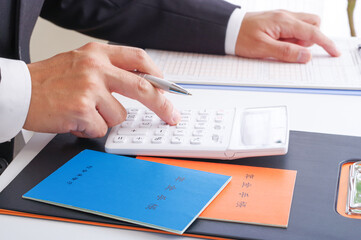 年金の受給額を計算するスーツ姿の男性