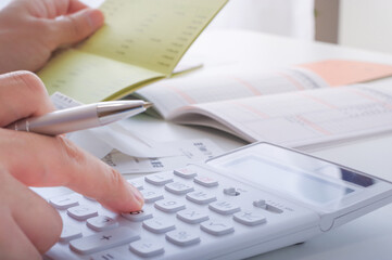 電卓でお金の計算をする人の手元