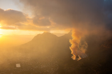 A controlled burn at sunrise at the foot of Table Mountain in Cape Town, South Africa. The view a morning hike to Lions Head.