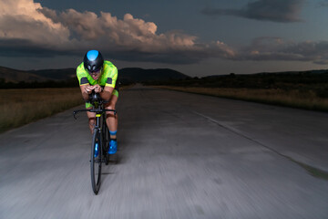 A triathlete rides his bike in the darkness of night, pushing himself to prepare for a marathon....
