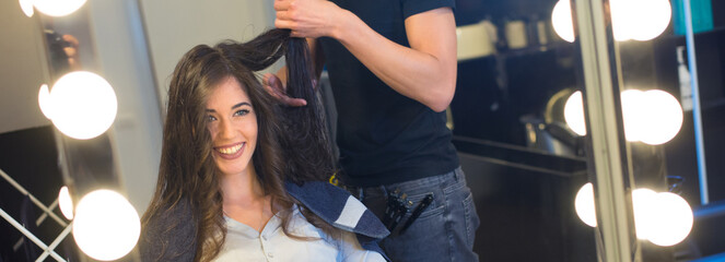 Young woman getting new hairstyle from a hairdresser in the modern hair salon	