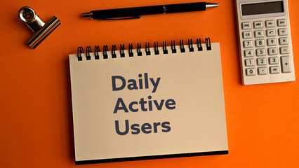 There is notebook with the word Daily Active Users.It is as an eye-catching image.