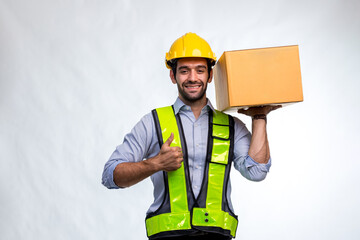 Delivery man employee in yellow hard hat hold cardboard box isolated on white background. Delivery man holding cardboard boxes. Smiling delivery man standing on white background