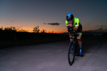 A triathlete rides his bike in the darkness of night, pushing himself to prepare for a marathon....