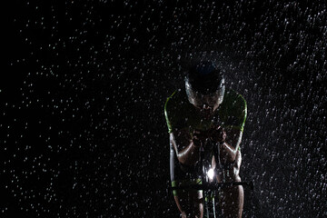 A triathlete braving the rain as he cycles through the night, preparing himself for the upcoming...