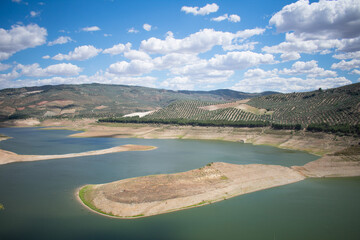 Landscape with a very large and green lake. Landscape with mountains full of olive trees and a clear sky. Typical landscape of the Spanish coasts. Typical Spanish landscape.