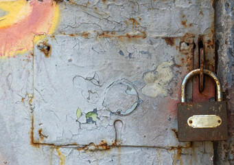 Old padlock hanging on rusty door