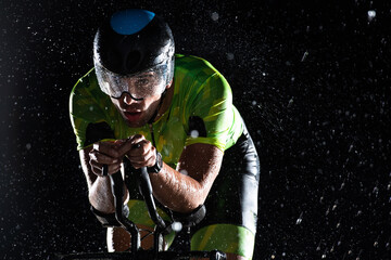 A triathlete braving the rain as he cycles through the night, preparing himself for the upcoming...