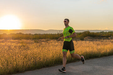Triathlete in professional gear running early in the morning, preparing for a marathon, dedication...