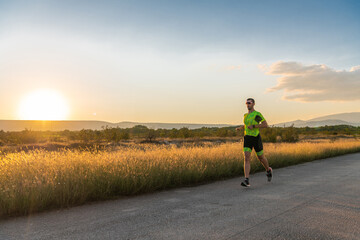 Obraz premium Triathlete in professional gear running early in the morning, preparing for a marathon, dedication to sport and readiness to take on the challenges of a marathon. 