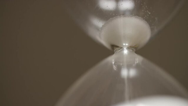 Sand in a hourglass almost emptying, symbol of time running out