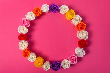 Round frame, wreath, circlet of multicolored soap roses on bright pink background, top view, flat lay. The concept of skin care, beauty, love, Valentine's Day.