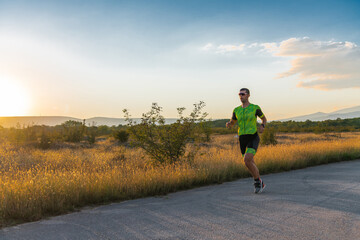 Obraz premium Triathlete in professional gear running early in the morning, preparing for a marathon, dedication to sport and readiness to take on the challenges of a marathon. 