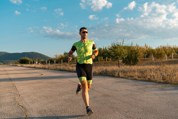 Triathlete in professional gear running early in the morning, preparing for a marathon, dedication...