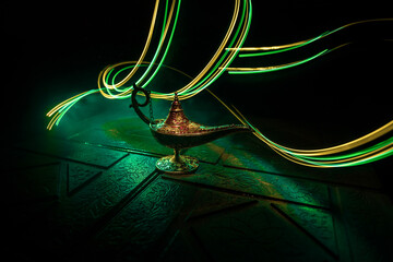 Antique Aladdin arabian nights genie style oil lamp with soft light white smoke, Dark background.