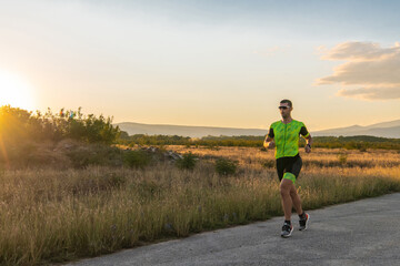 Obraz premium Triathlete in professional gear running early in the morning, preparing for a marathon, dedication to sport and readiness to take on the challenges of a marathon. 