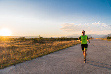 Obraz premium Triathlete in professional gear running early in the morning, preparing for a marathon, dedication to sport and readiness to take on the challenges of a marathon. 