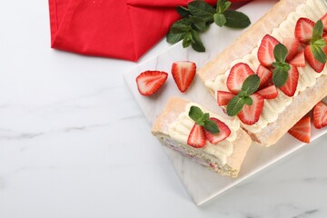 Delicious cake roll with strawberries and cream on white marble table, top view. Space for text