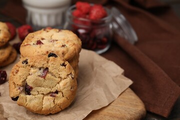 Cookies with freeze dried fruits on wooden board, closeup. Space for text