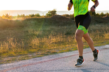 Triathlete in professional gear running early in the morning, preparing for a marathon, dedication to sport and readiness to take on the challenges of a marathon. 