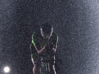 A triathlete braving the rain as he cycles through the night, preparing himself for the upcoming...