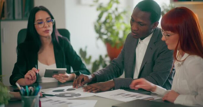 Corporate employees during meeting in office discussing topics related to sales