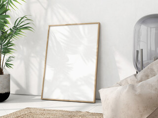 Single large wooden frame on white herringbone parquet, in a white modern interior with tropical plant