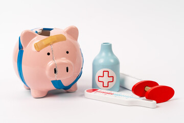 Broken, glued piggy bank with medical syringe, thermometer. An image of cost of medicine, health. Investment in life insurance. Paid health care, benefits for pensioners for treatment, hospitalization