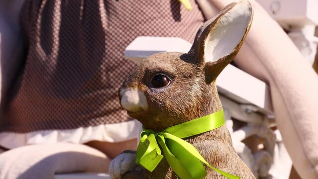 Easter in spring season with a rabbit decoration with a green scarf, and colorful blurred background in Mosonmagyar&oacute;v&aacute;r , Hungary , Europe .