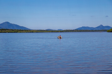 Naklejka premium Aerial view of the city of Cananéia. Mangrove and sea in Ilha do Cardoso State Park. With man fishing in a boat