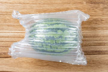 top view fresh watermelon wrapped by air protector horizontal composition