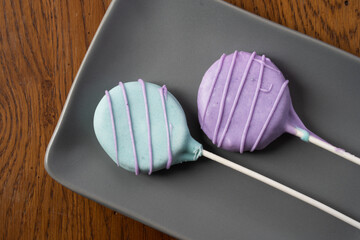 Colorful homemade cake pops on gray plate.
