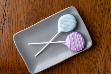 Colorful homemade cake pops on a gray plate.
