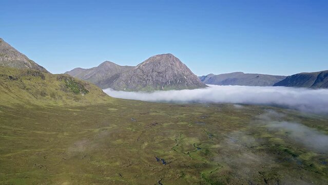 Aerial view of remains of low banks of fog with mountain peaks at dawn (Glencoe, Scotland)