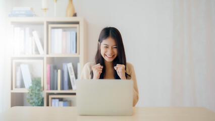 Funny euphoric young asian woman celebrating winning or getting ecommerce shopping offer on...