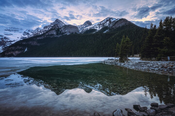 Lake Louise at Banff National Park, Alberta, Canada during May when there is still snow and ice on the lake and mountain peak - 602472300