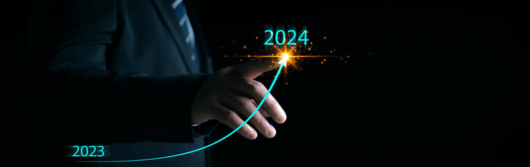 New years 2024 start up investment new business and finance. Businessman hand pointing graph on...