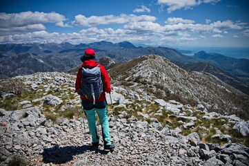 Rear view of senior woman hiking in rocky landscape in Croatia