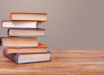 Stack of books on a wooden table with copy space.