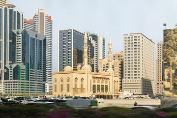 Fototapeta na wymiar View from the window of the tourist bus to the Al Rahimoon Mosque and nearby buildings in Sharjah city, United Arab Emirates
