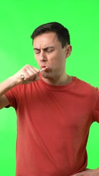 Male in red t shirt brushing teeth