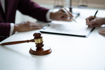 Professional lawyer reading agreement contract document and explaining legal agreement terms to his client.