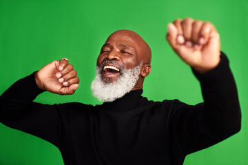 Happy, dance and face of of black man on green screen for celebration, music or excited. Happiness, smile and energy with senior person dancing isolated on studio background for freedom and movement