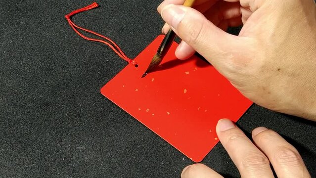 Written Chinese Calligraphy characters, translation:"safe and well" on Red Sprinkled Gold Card.