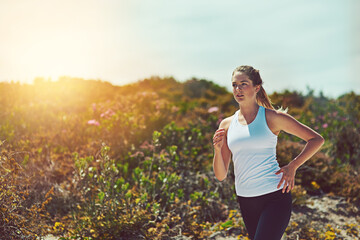 Woman running in nature, fitness outdoor with cardio and training for marathon with young athlete and sports. Female runner in bush, sunshine and run for exercise with healthy person and mockup space