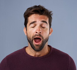 Tired, yawn and man in studio for fatigue or low energy against a grey background. Exhausted, yawning and face of bored male sleepy, lazy or suffering from insomnia, problem or burnout with emoji