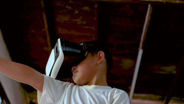 Asian boy using 3d vr glasses and toy gun for digital virtual gaming. Boy playing digital virtual gaming with modern gadget. 4K