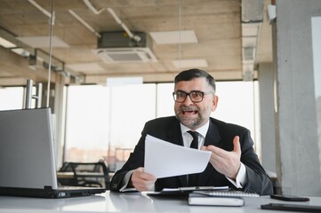 Fototapeta premium Angry businessman with document shouting at somebody