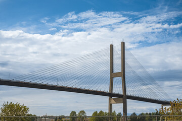 Modern bridge pylon against blue sky. Multi-span cable-stayed bridge. White cable-stayed suspension Alex Fraser Bridge