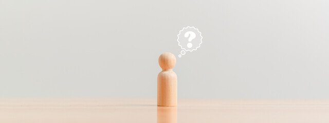 Wooden figurine as person who have questions and need help solving the problems. Man has no idea on...